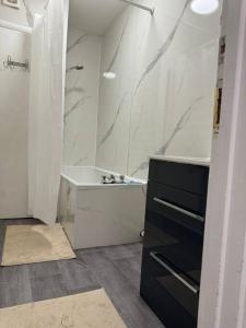 a bathroom with a shower and a sink and a tub at 4 Bedroom Entire Flat, Kings Cross Road in London