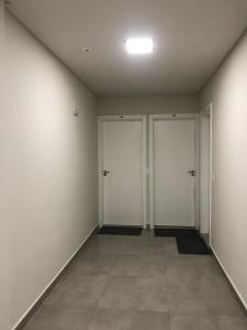 an empty room with three doors and a tile floor at Apto 70m² no centro de Porto Belo in Porto Belo