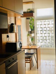 a kitchen with a table and a microwave at Apartamento T1 no centro TÊ-U in Torres Vedras