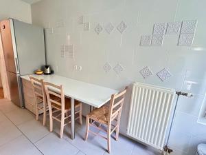 uma cozinha com uma mesa e cadeiras e um frigorífico em Room for women - Room C em Vitry-sur-Seine