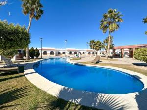 a swimming pool in a resort with palm trees at Mexican Ambience Townhome with Pool #1 in Puerto Peñasco