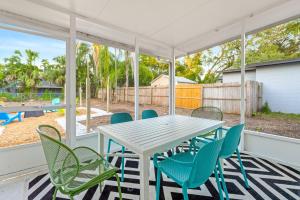 a table and chairs on a porch with a view of a playground at Fire Pit + Grill + 2MI to DT Orlando in Orlando