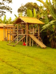 a small wooden structure with a roof on the grass at Sossego Da Mata in Santo Antônio do Leite