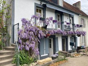 een huis met paarse blauweregen aan de zijkant bij Le Lodge de Serenite in Cuffy