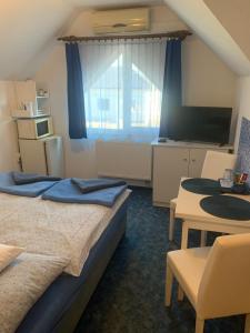 オロシュハーザにあるNapfény apartmanのベッド2台とテーブルが備わるホテルルームです。
