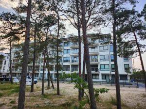 羅威的住宿－Apartament, Wypoczynkowa Rowy，公寓大楼前面有树木