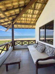 a living room with a couch and a view of the beach at Itacimirim Apartments Boulevard e Ondas in Itacimirim