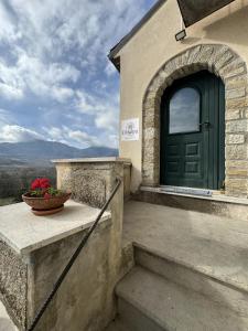 a building with a green door and a bowl of flowers at B&B I Mulini in Santa Maria del Molise