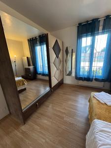 - une chambre avec un grand miroir et un lit dans l'établissement Chez Chantou à Pierrefitte sur Seine, à Pierrefitte-sur-Seine