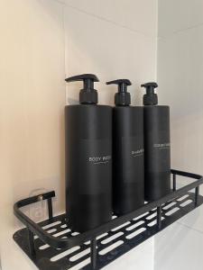 two black water bottles sitting on a black shelf at Willow’s Abode: Luxury One Bed in Newton in Makerfield