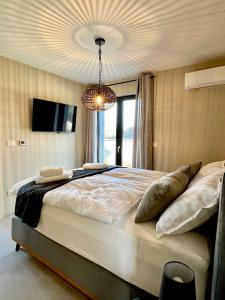 a bedroom with a large bed and a chandelier at Villa Maslinik in Kaštelir +13 photos