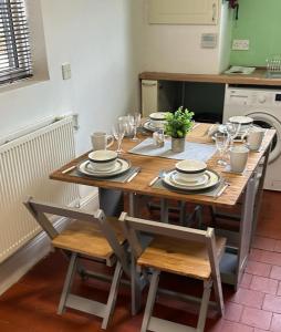 a table with plates and glasses on it in a kitchen at West Street House in Crewe