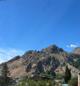 a mountain in the distance with a blue sky at Hotel Sur Sur Patagónico in Esquel