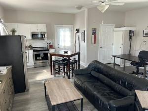 a living room with a black couch and a kitchen at Private Studio in Davidson NC in Davidson