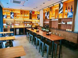 un bar con mesas de madera y sillas en un restaurante en APA Hotel Namba-Shinsaibashi Nishi en Osaka