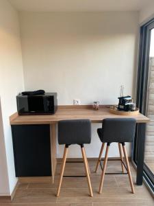 a wooden table with two chairs and a microwave at Suite romantique SPICY LOVE - proche Nice et Cannes - Jacuzzi privatif - French Riviera - luxe in Villeneuve-Loubet +8 photos