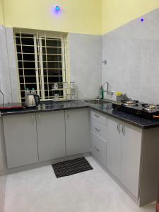 eine Küche mit weißen Schränken und einer Arbeitsplatte in der Unterkunft New Paradise 2BHK Bangalore Near BIEC & IKEA in Bangalore