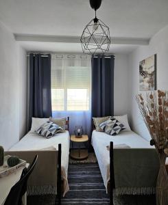 duas camas num quarto com cortinas azuis em CASA BLANCA em Santa Pola