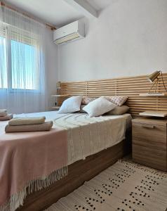 um quarto com uma cama grande e uma cabeceira em madeira em CASA BLANCA em Santa Pola