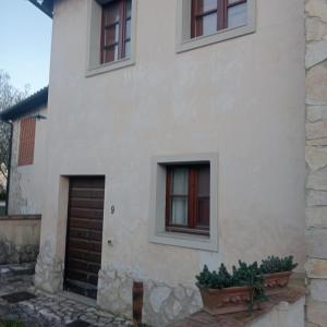 een wit huis met twee ramen en een deur bij Casa Vacanze Giodo in San Vivaldo