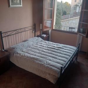 ein Bett in einem Schlafzimmer mit einem großen Fenster in der Unterkunft Casa Vacanze Giodo in San Vivaldo