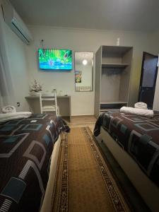 - une chambre avec 2 lits et une télévision murale dans l'établissement Hotel Bar-Restorant Fresku, à Fushë-Arrëz