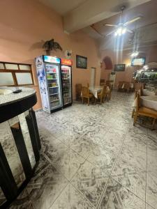 - un restaurant avec un réfrigérateur, des tables et des chaises dans l'établissement Hotel Bar-Restorant Fresku, à Fushë-Arrëz
