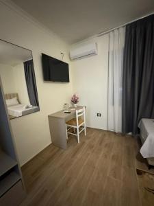 Cette chambre comprend un bureau, un lit et une chambre. dans l'établissement Hotel Bar-Restorant Fresku, à Fushë-Arrëz