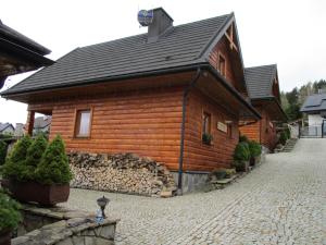 uma casa de madeira com um telhado numa rua de tijolos em Chaty Wichrowe Wzgórze em Krynica-Zdrój