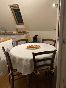 a kitchen with a table with a plate of oranges on it at Chambre Avenue Foch in Paris