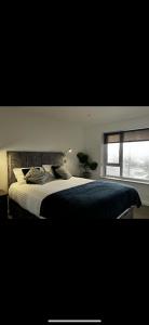 a bedroom with a large bed with a window at Prospect View in Portstewart