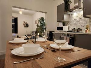 Una mesa de madera con platos y copas de vino encima. en SuperValue Suite 6 - Fast WiFi, Hotel Linen, Keyless Entry, City only 10 Mins - BY PROPERTY PROMISE, en Cardiff 14 fotos más