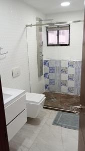 uma casa de banho com um WC e uma cabina de duche em vidro. em APARTAMENTO DE 3 ALCOBAS H-8MR CERCA AL MAR CON PISCINA AIRE ACONDICIONADO Y WIFi em Cartagena das Índias