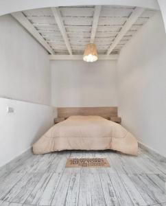 Habitación blanca con cama y lámpara de araña. en Casa Blanca en Santiago del Estero