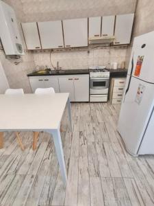 cocina con mesa blanca y nevera en Casa Blanca en Santiago del Estero