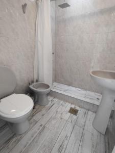 a white bathroom with a toilet and a sink at Casa Blanca in Santiago del Estero