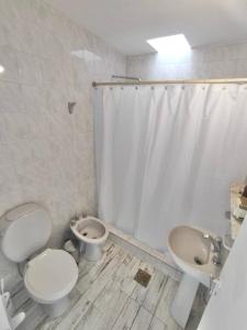 een badkamer met een toilet, een bidet en een wastafel bij Casa Blanca in Santiago del Estero