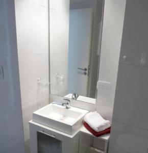a white bathroom with a sink and a mirror at Palermo Soho Apartamento in Buenos Aires