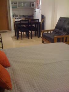 ein Wohnzimmer mit einem Sofa, einem Tisch und Stühlen in der Unterkunft Palermo Soho Apartamento in Buenos Aires