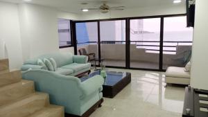 uma sala de estar com um sofá azul e cadeiras em APARTAMENTO DE 3 ALCOBAS H-8MR CERCA AL MAR CON PISCINA AIRE ACONDICIONADO Y WIFi em Cartagena das Índias