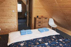 um quarto com uma cama num chalé de madeira em Domek letniskowy Letniczówka em Warchały