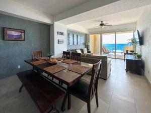 a dining room with a table and a living room at Family friendly Condo with Oceanfront Views in Puerto Peñasco