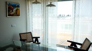 a dining room with a glass table and chairs and a window at OASIS in Buarcos