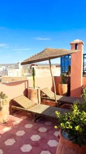 a patio with two chairs and an umbrella at Riad Dar Latigeo in Essaouira