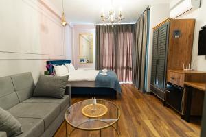 - un salon avec un canapé et un lit dans l'établissement Trinity Hotel, à Tbilissi