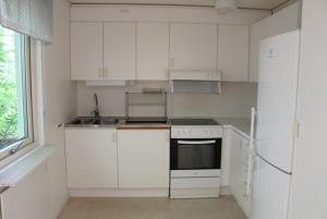cocina blanca con armarios blancos y ventana en Sandby Pensionat, en Löttorp