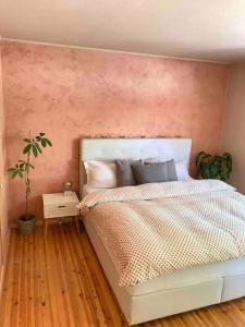 1 dormitorio con 1 cama con pared de color rosa en The best view in Oslo en Oslo