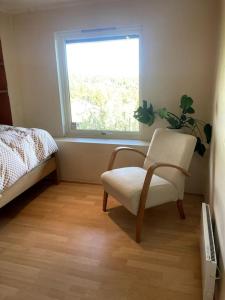 a bedroom with a white chair and a window at The best view in Oslo in Oslo