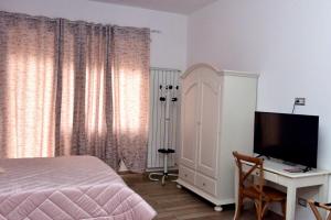 a bedroom with a bed and a desk with a television at In Terrazza Da Giusy in Rome