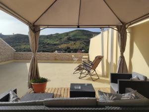 a view of a patio with chairs and an umbrella at Buena Vista House by Canarias Homelidays in Santa Brígida